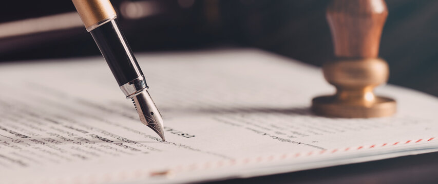 Notarization of Will and Trust document with fountain pen and official notary stamp on a legal form.