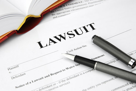 Civil Summons document with pen and legal book, representing lawsuit filing or response process.