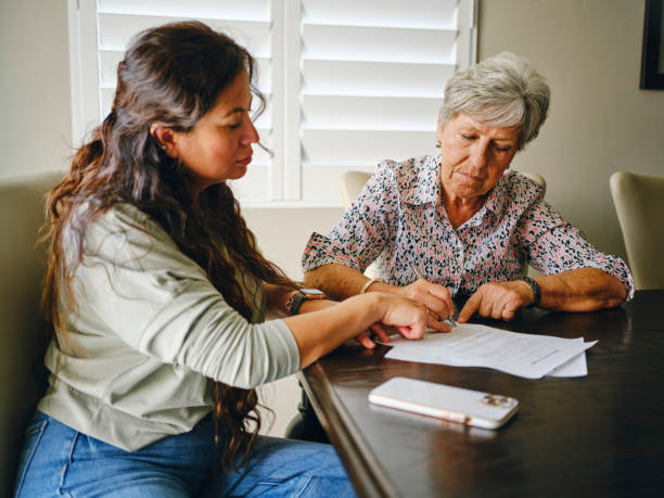 Two women reviewing and signing a power of attorney document with assistance from Fingerscan Digital Inc and TrustPoint Disability & Legal Services in San Jose.