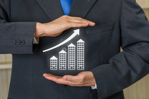 "Businessperson in suit holding a rising bar graph made of building icons, representing real estate or financial growth